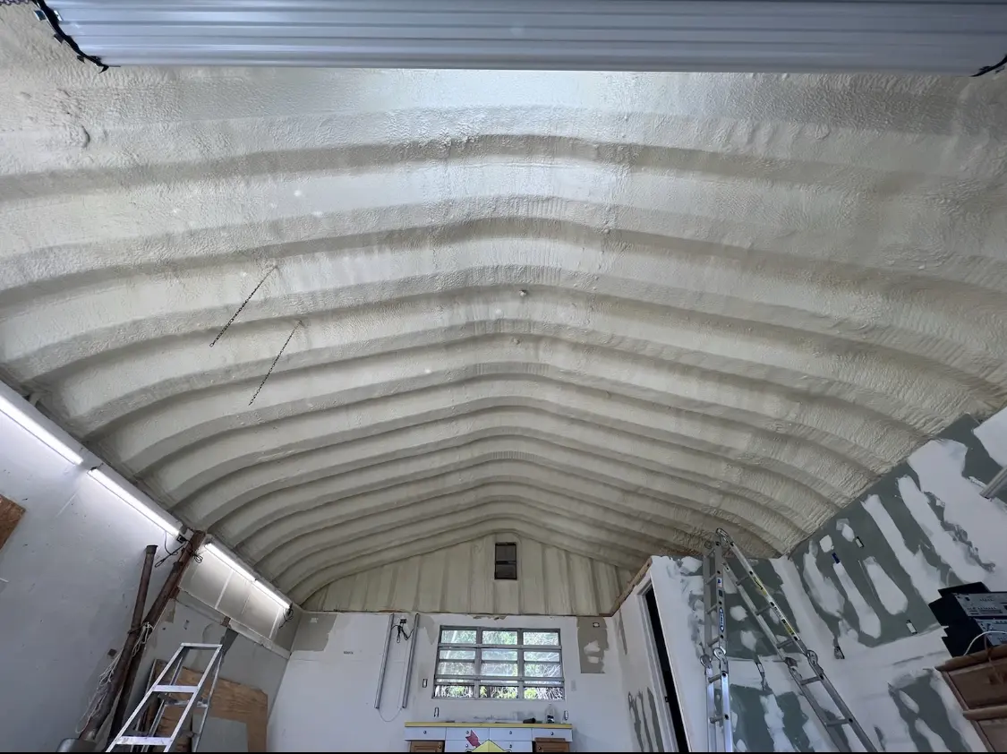 Spray polyurethane foam applied to the underside of a metal roof deck in Dent